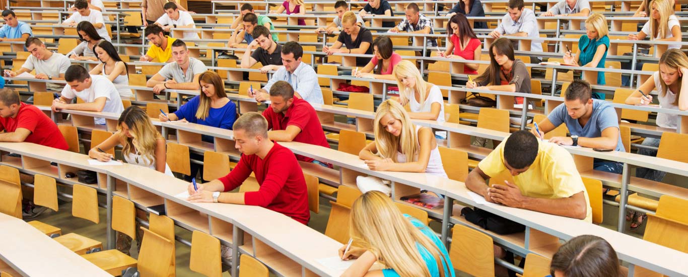 Group of people writing the GED® test in a lecture hall.